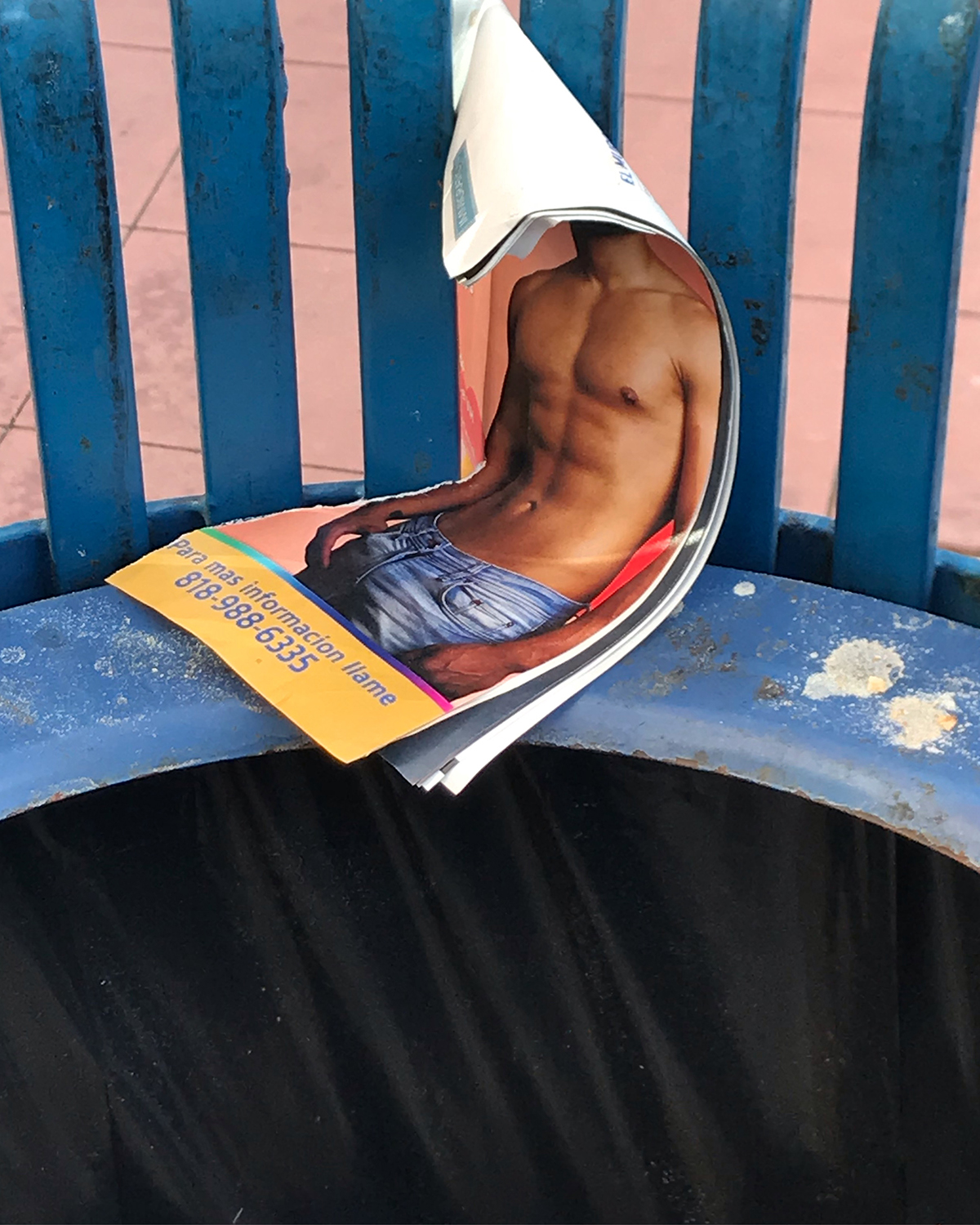 Surreal urban photograph of a man's torso torn out of a magazine on a bench