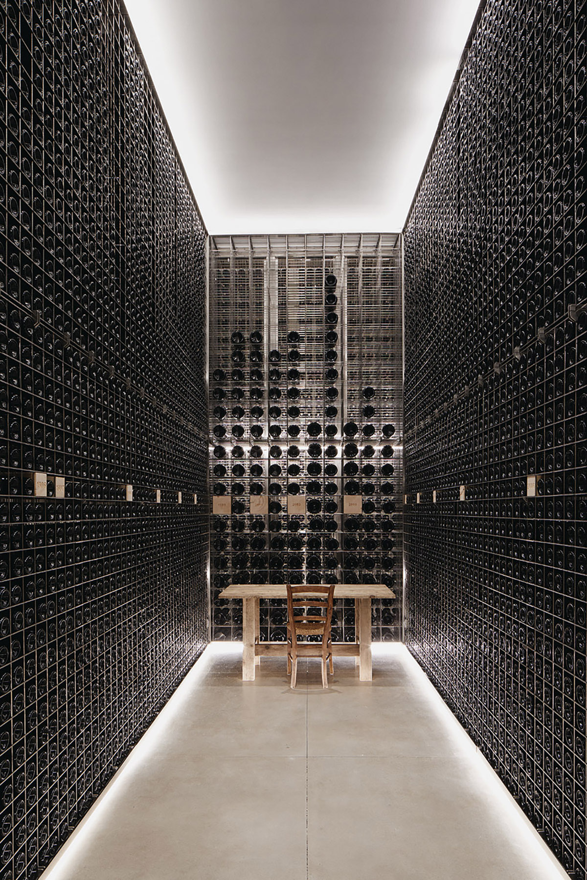 A slim wine cellar with bottles from ceiling to ground