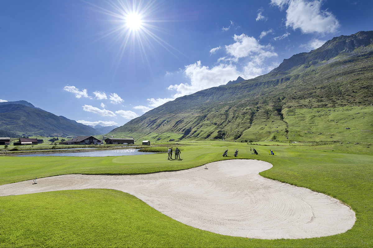 Green of a golf course surrounded by mountains