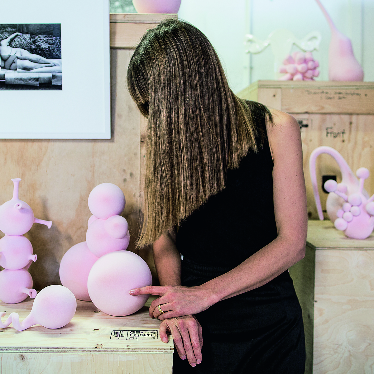 Artist touching a pink ceramic sculpture