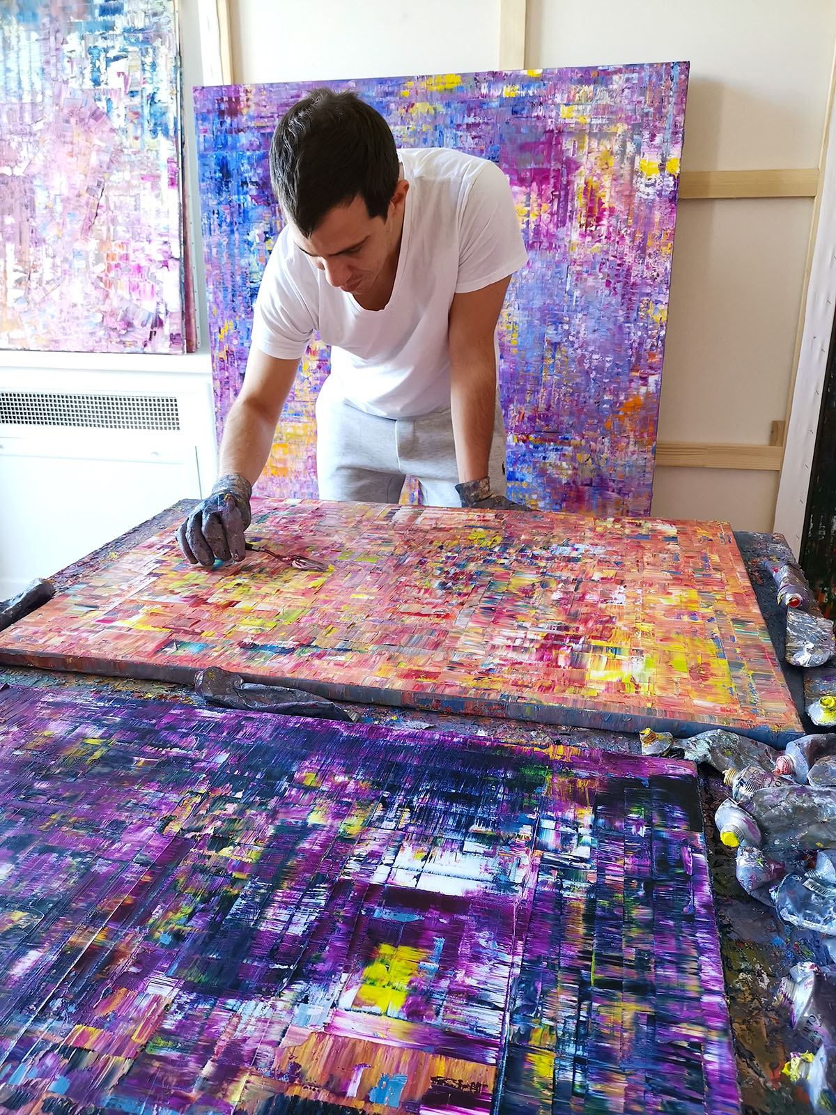 Artist in the process of painting onto a large canvas