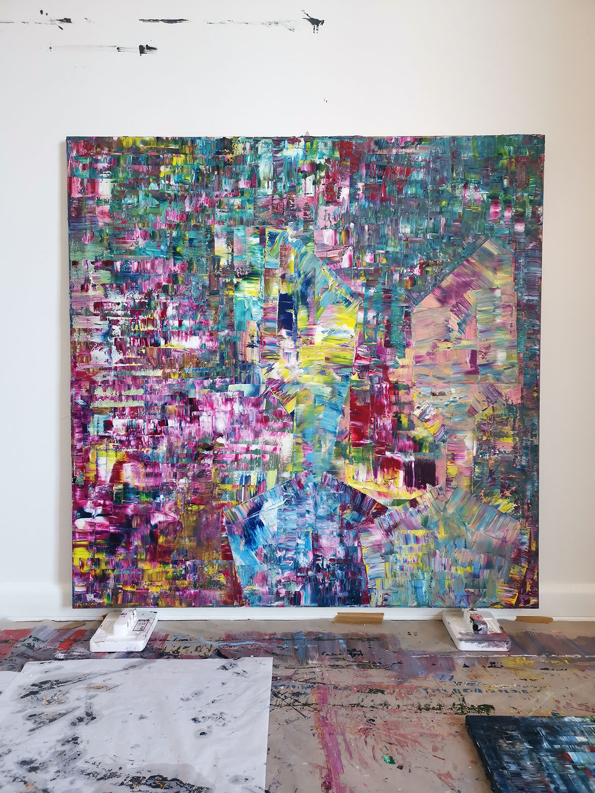 Large scale abstract painting hanging on a studio wall