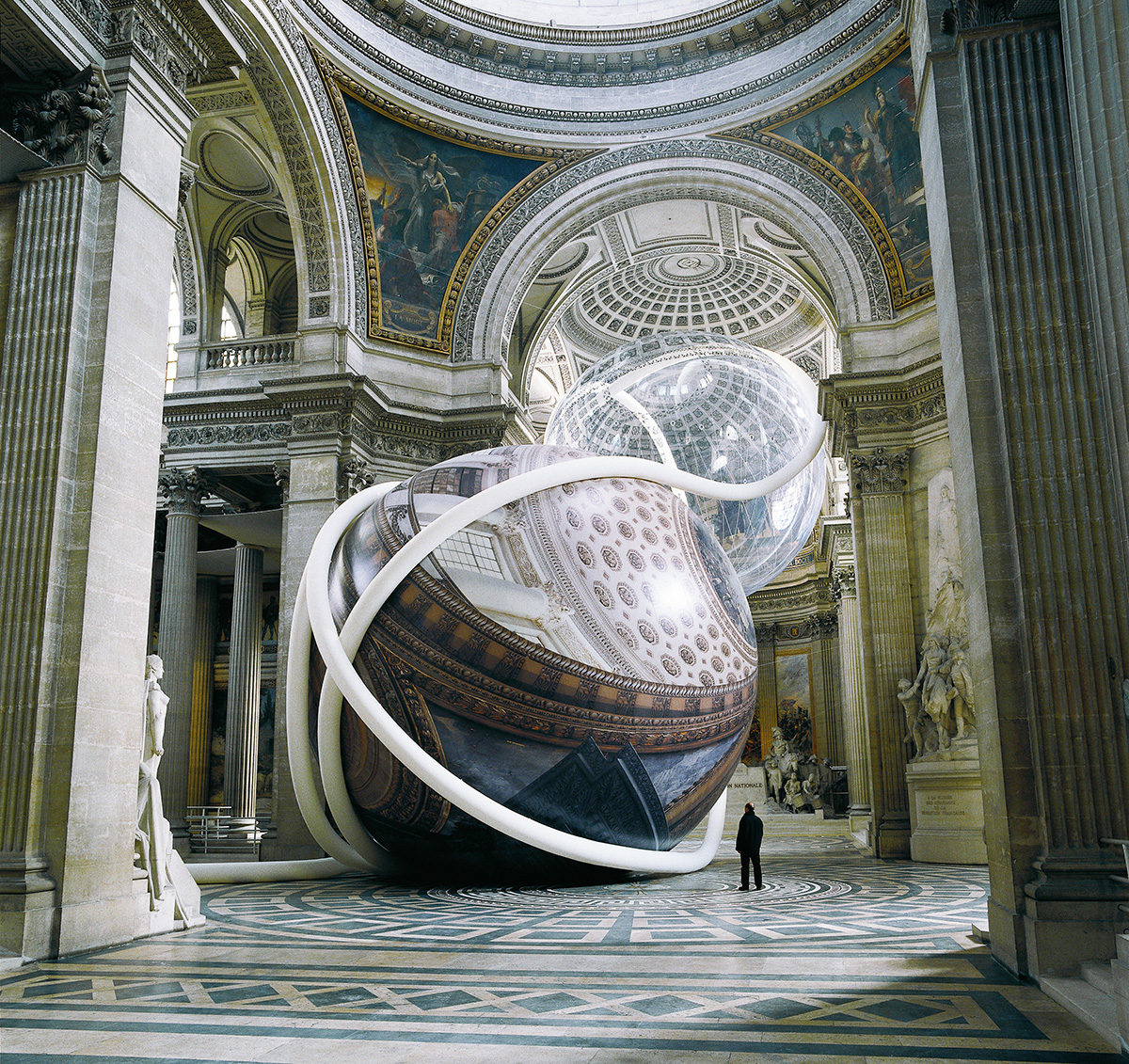 Large scale sculpture depicting a sphere inside a museum setting