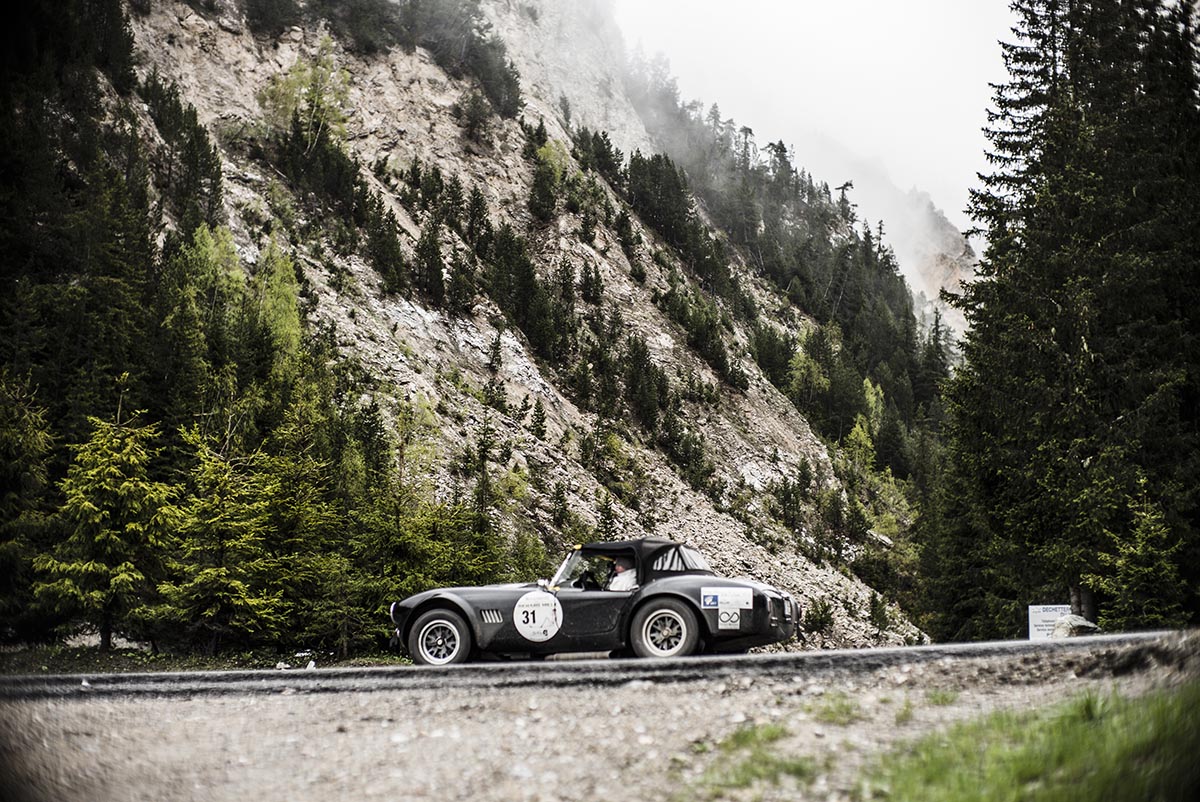 Classic car driving along a mountain road