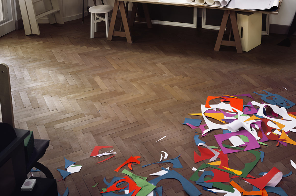 Coloured paper cutouts scattered on a wooden floor