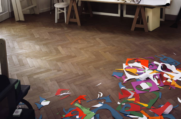 Coloured paper cutouts scattered on a wooden floor