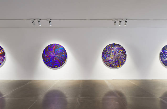 Installation view of a contemporary art exhibition with round canvases