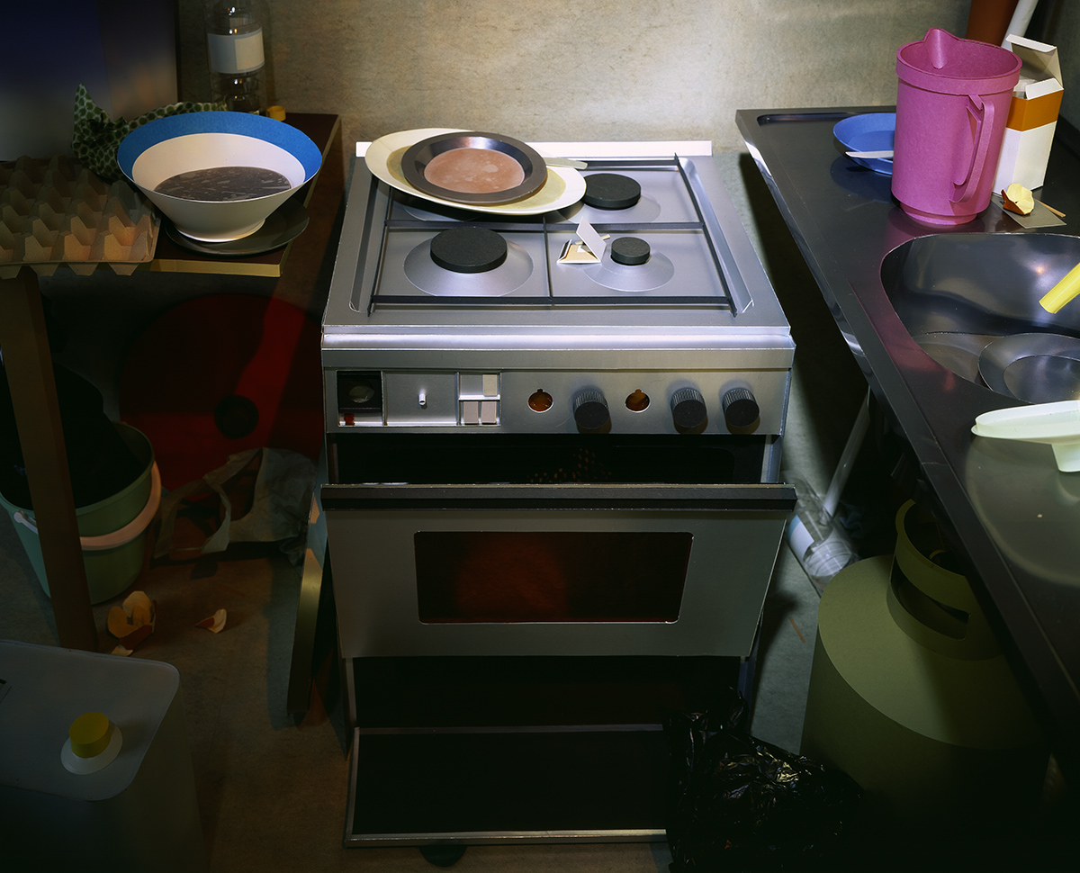 Photograph of a small silver gas cooker and kitchen 