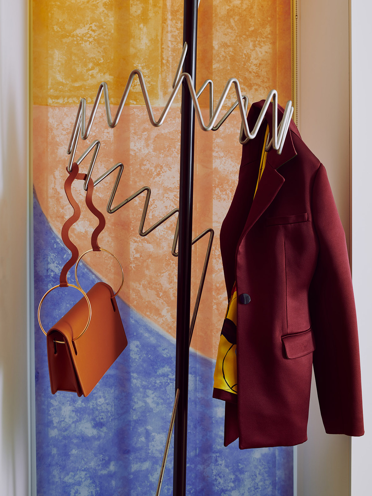 Coat and bag hanging on contemporary style zigzag coat hanger