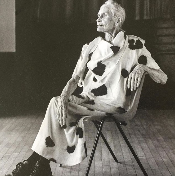 Elderly woman poses sitting in a chair