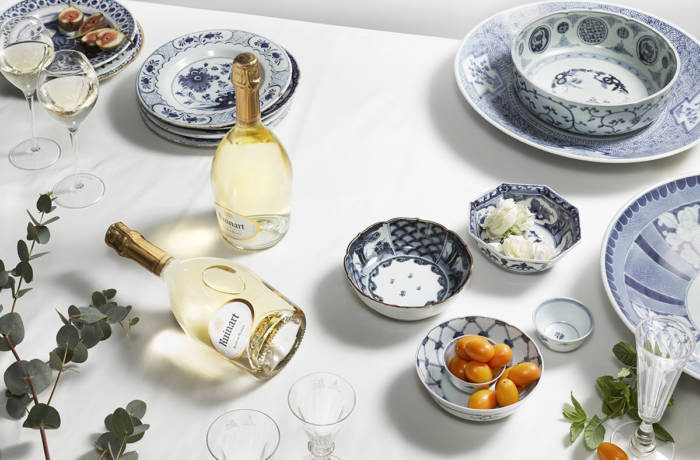 Dinner table laid out with champagne bottles and antique plates