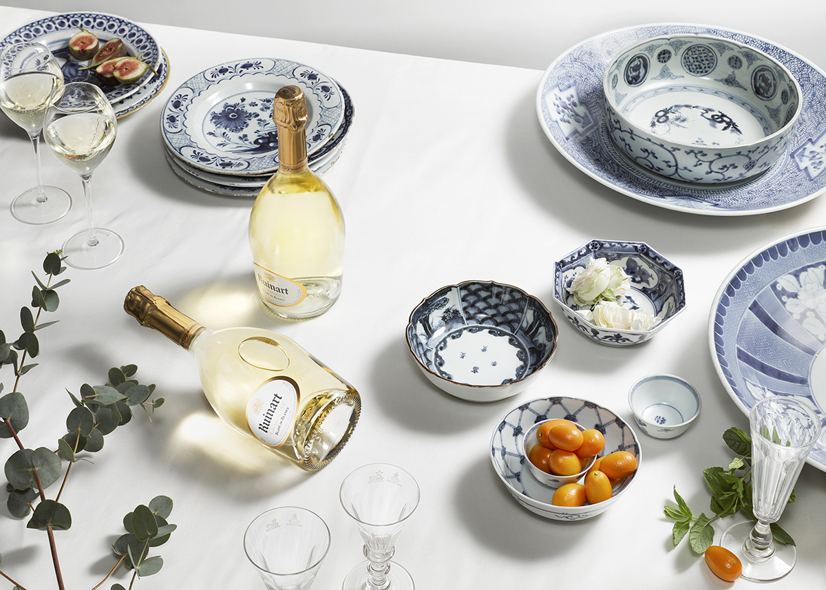 Dinner table laid out with champagne bottles and antique plates