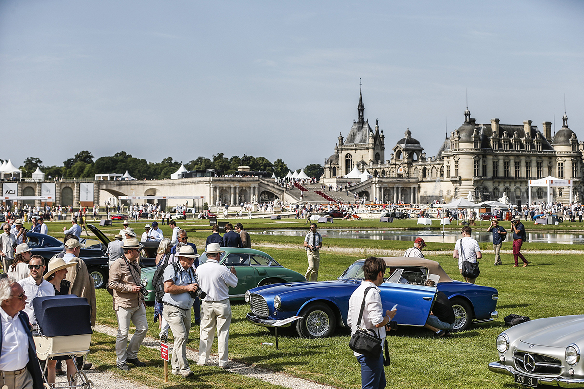 People at a car show in the setting of a stately home