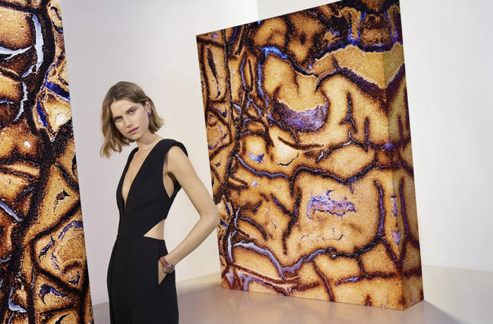 Model posing with large contemporary artworks