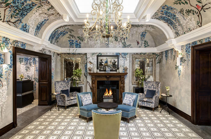 Luxury hotel interiors of a drawing room with painted walls and soft furnishings