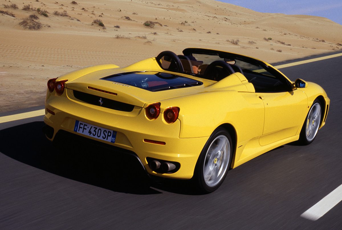 Yellow sports car driving along a desert road