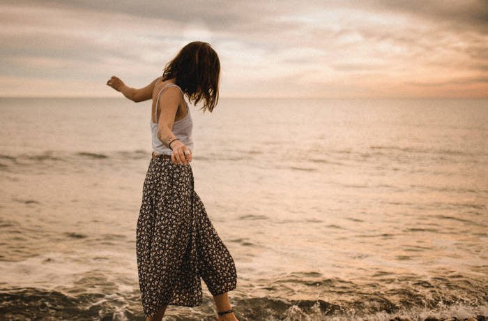 Woman walking bare foot along the beach