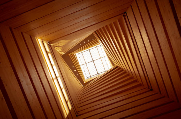 Contemporary light well inside a building made from wooden panels
