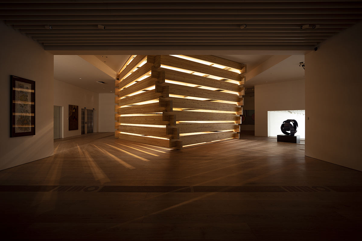 Interiors of an art gallery space with wooden light well feature at centre