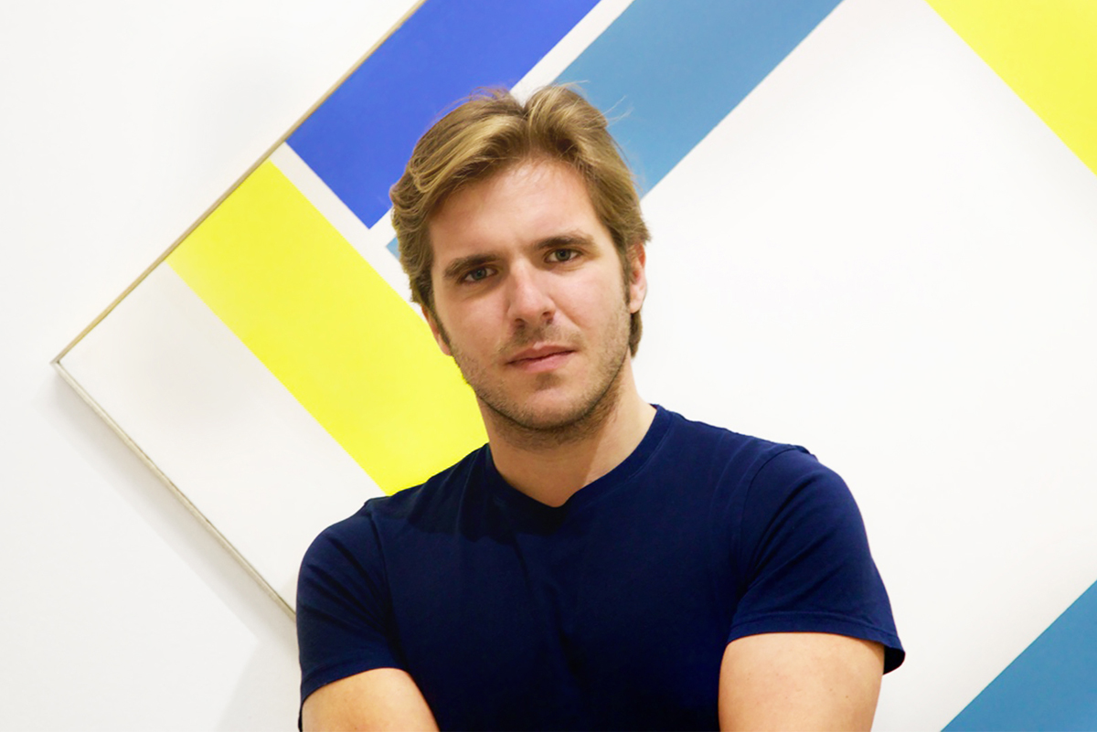 Portrait of a young man in front of a geometric art work