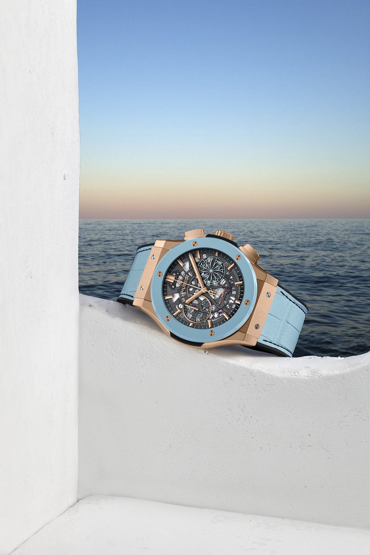 Luxury watch lying on a white wall with ocean in background