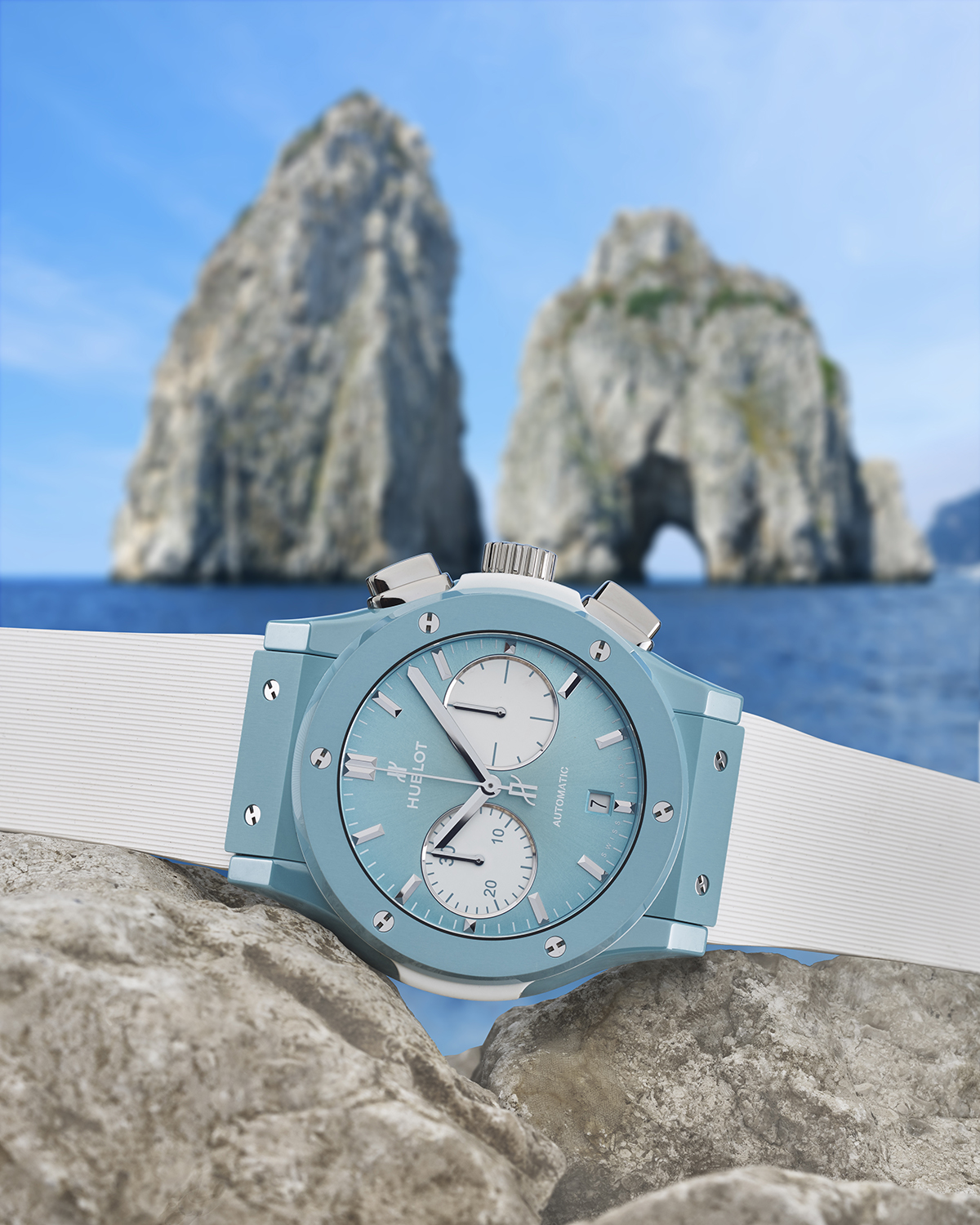 Luxury blue and white watch pictured on sand