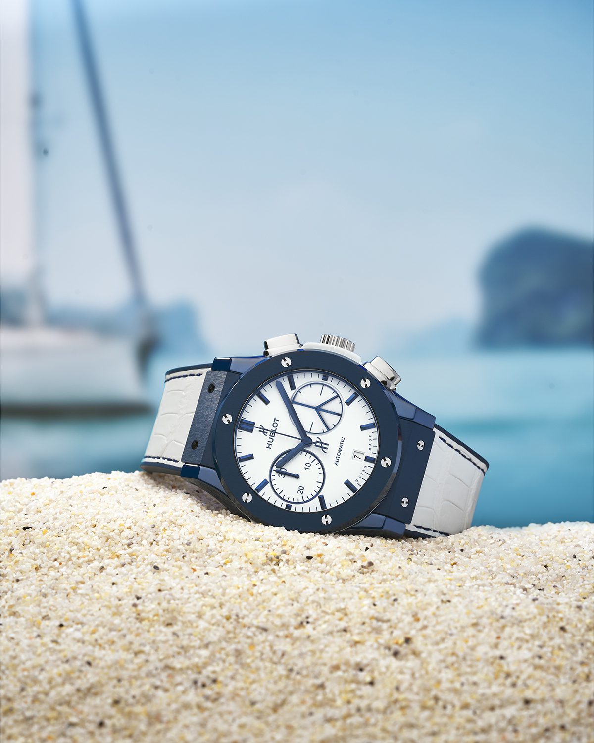 Luxurious blue and white watch pictured on sand