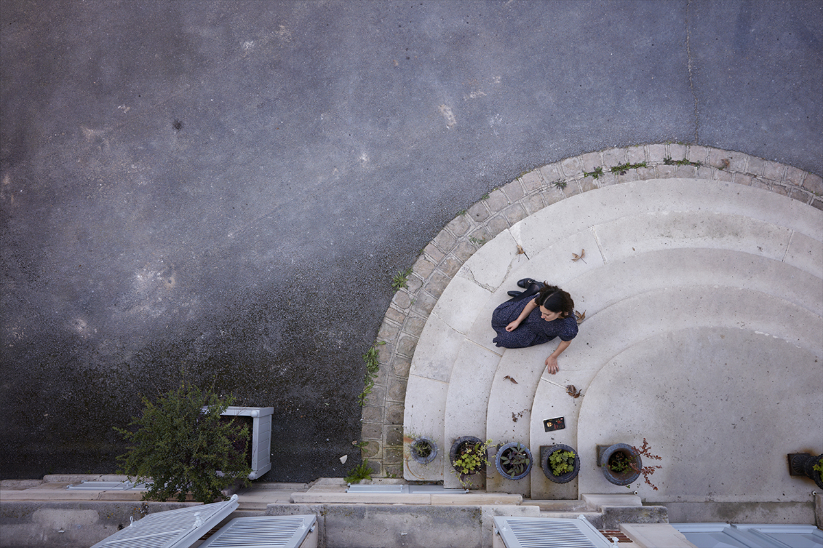 Aerial image of a woman sitting on curved steps