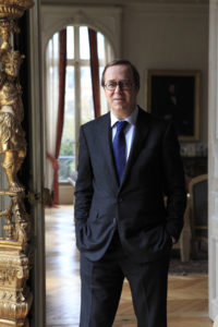 Man in a suit and glasses standing in a hotel