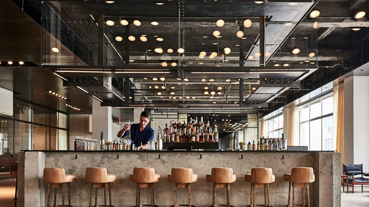 Contemporary style bar with barman mixing at the counter