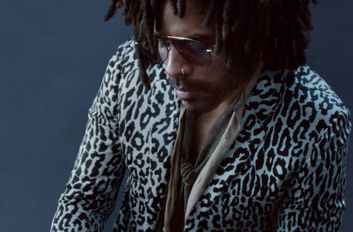 Lenny Kravitz wearing an animal print blazer holding champagne