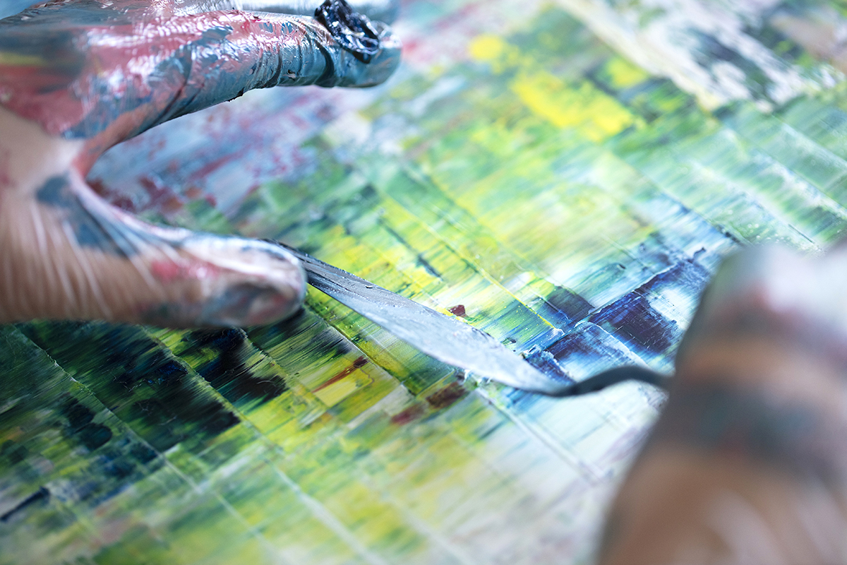 Detail shot of an artist scraping paint 