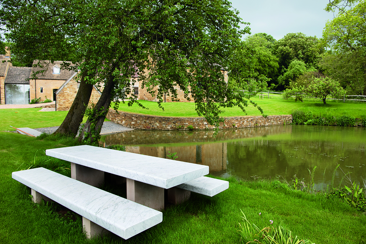 Gardens of a country home with a marble bench