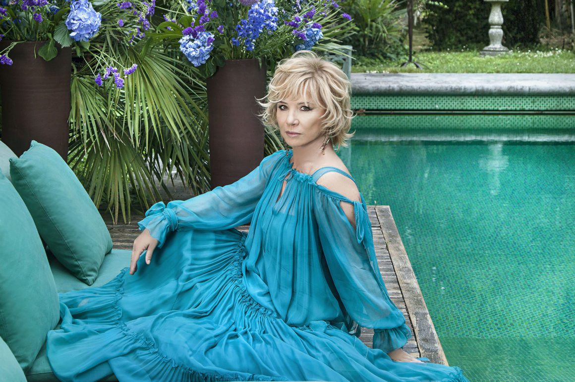 Glamorous woman lounging by exotic pool