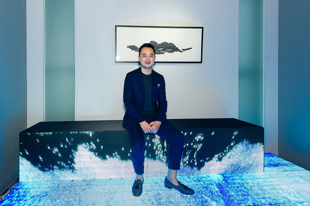 Asian man in suit sitting in installation artwork