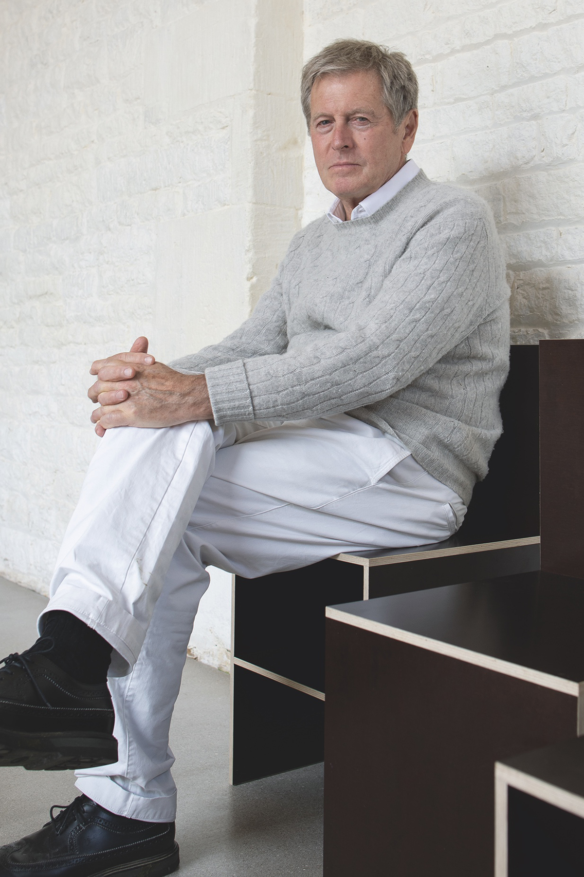 Man sitting on bench in white room