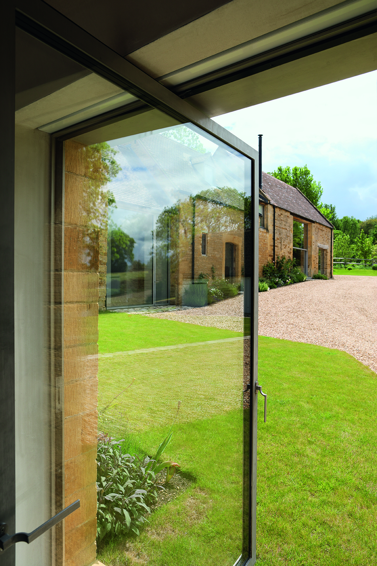 View through an open glass door onto barn