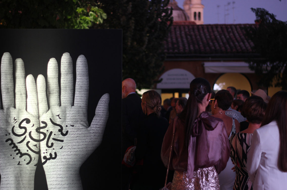Courtyard party showing large monochrome artwork of hands