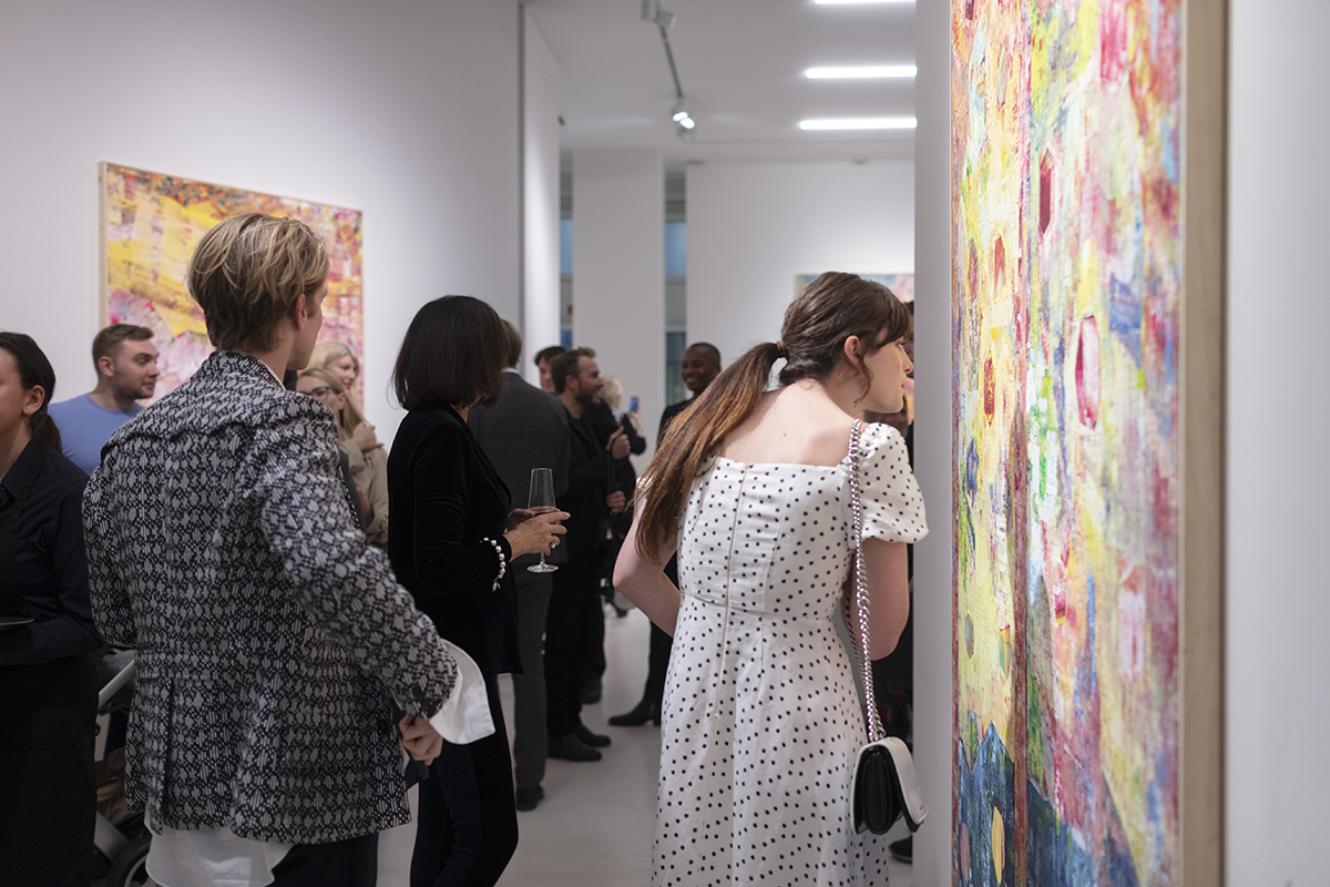 Guests admiring artworks in gallery opening