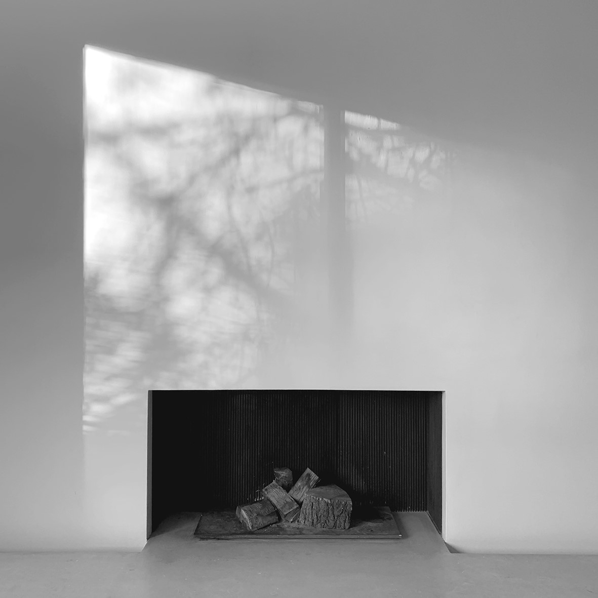 Fire place photographed in black and white with light and shadow on wall