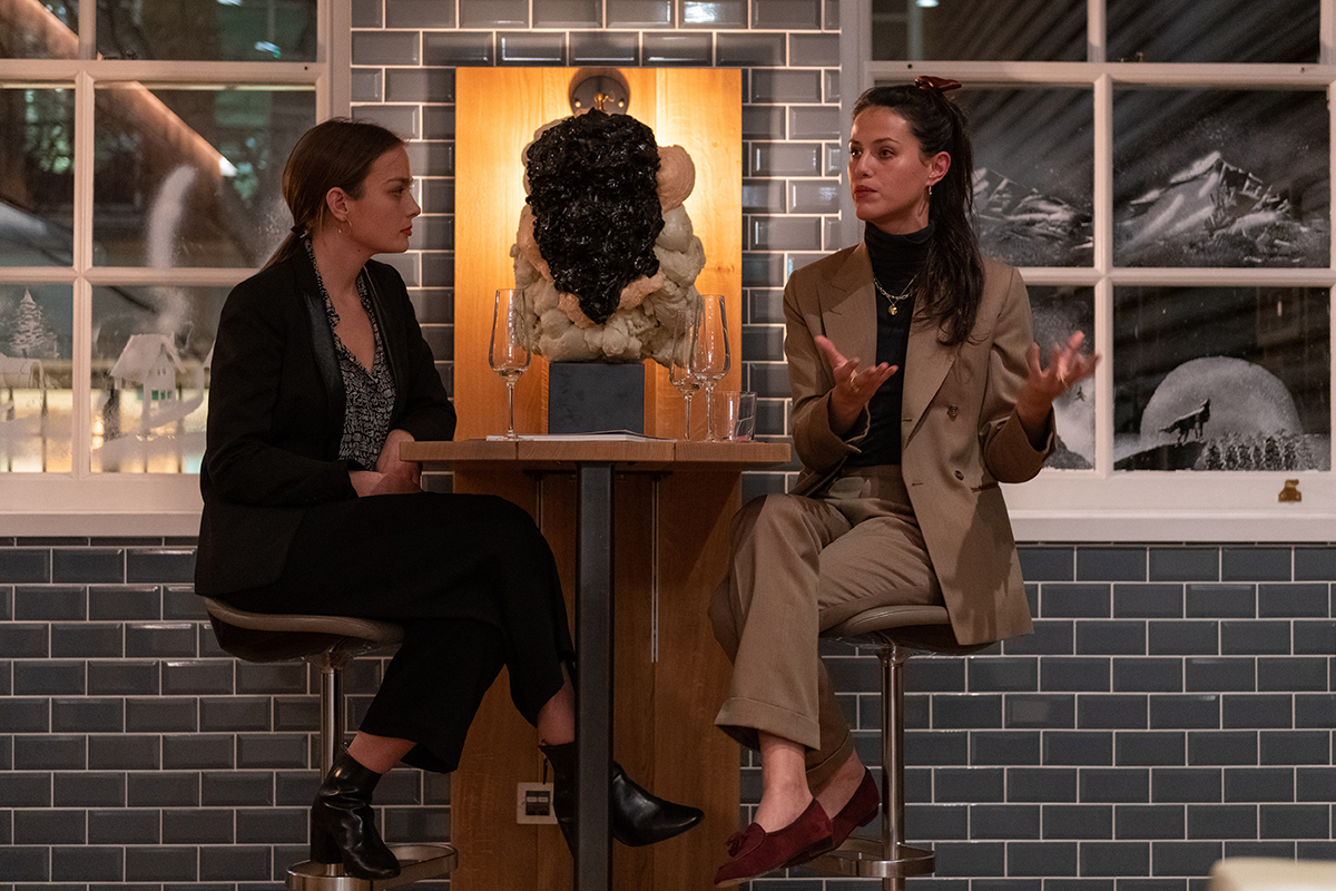 Two women in conversation on high stools