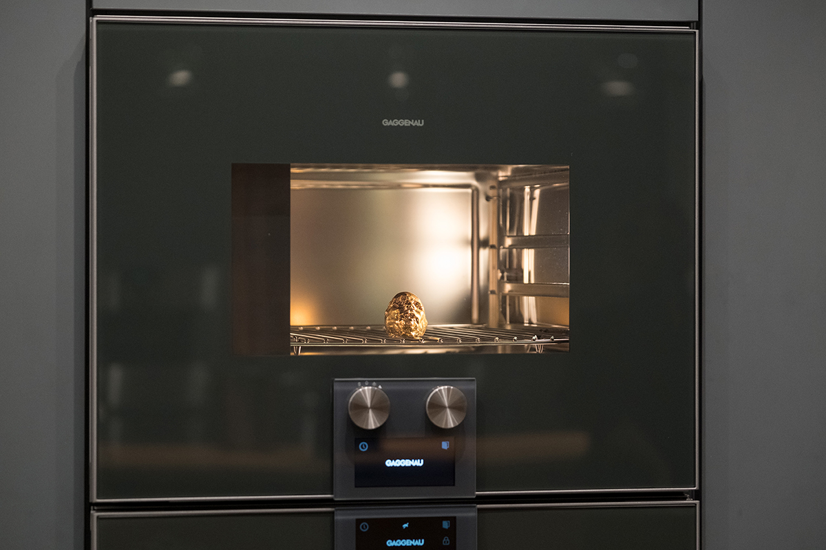 A small gold head sculpture inside an oven