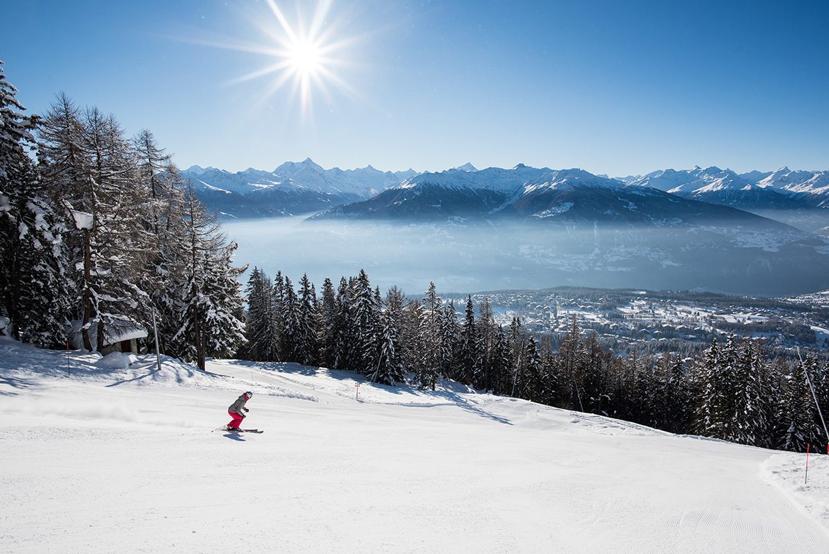 Skiier on a slope down into the valley