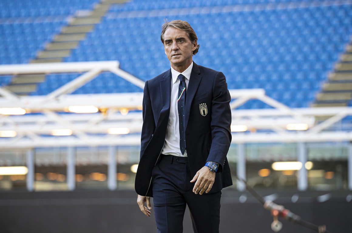 Man walking across stadium wearing watch