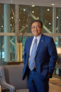 Asian man in suit standing in lounge