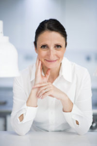 Female chef in white shirt inside kitchen