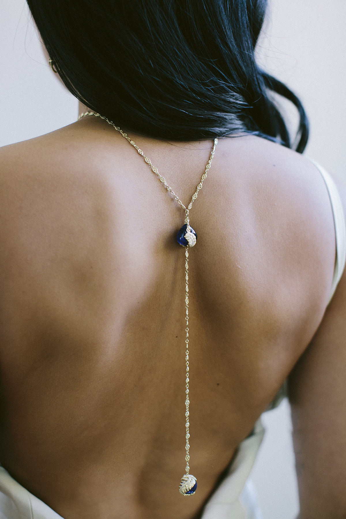 Long necklace worn on model's back