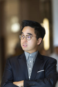 Portrait of an Asian man wearing a suit and glasses