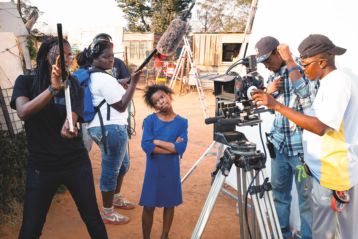 Camera crew recording a young girl in Africa
