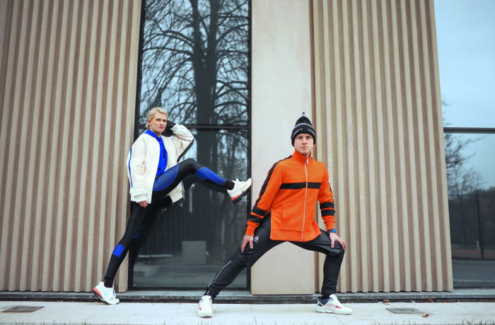 Man and women wearing gym kit outside a building